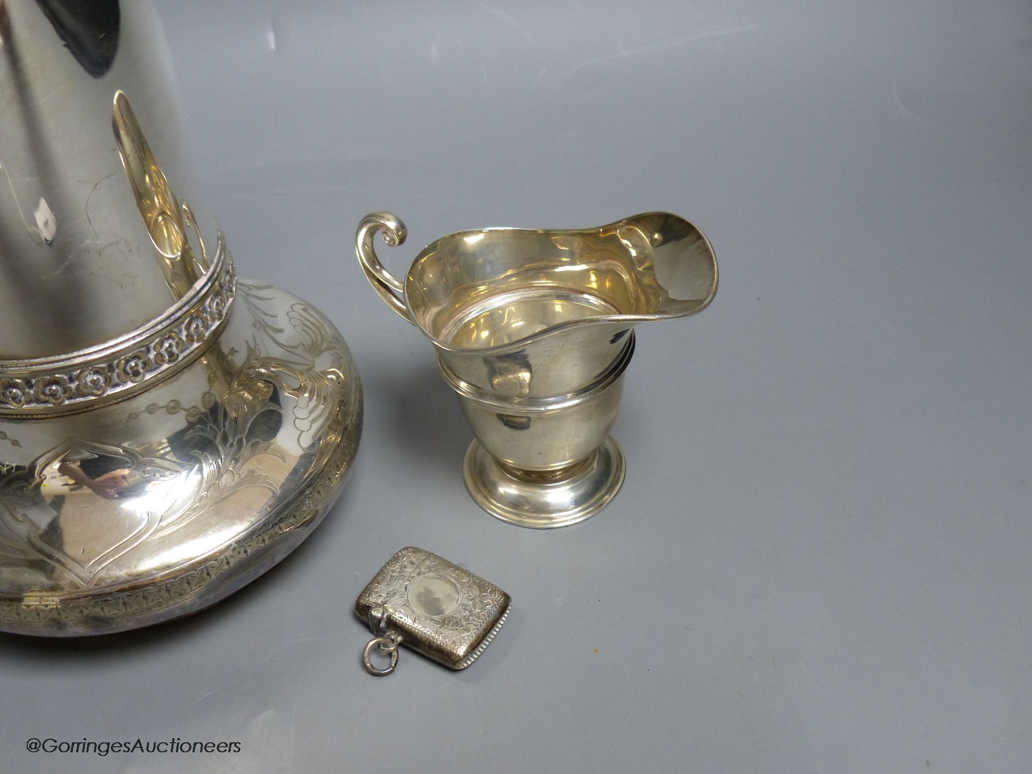 A Victorian Elkington & Co silver plated hot water jug, 27.7cm, an Edwardian silver cream jug and similar silver vesta case.